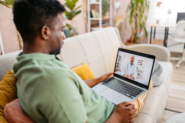 istock Young Man Having A Doctor's Appointment On The Laptop On The Sofa 2172364270
