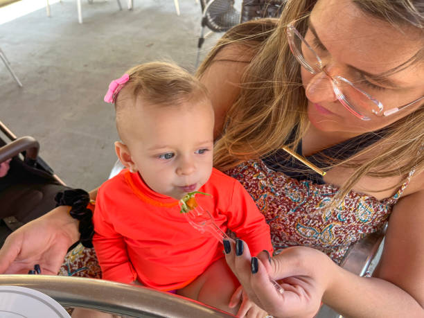 istock Mother feeding one year old baby daughter 2172364370
