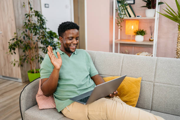 istock Young Man Having A Work Video Call On A Laptop On The Sofa 2172366282