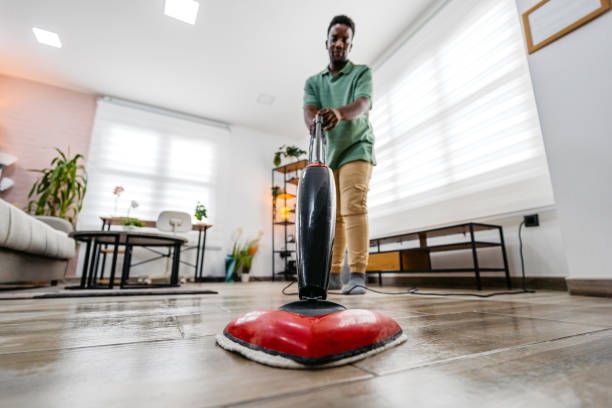 istock Young Man Vacuuming The Carpet In His Apartment 2172366444