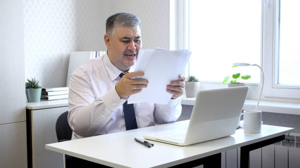 istock Man in Office Upset While Reviewing Documents at Desk 2172368117