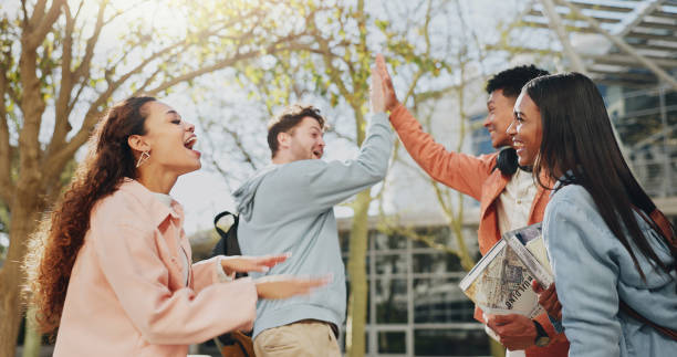 istock High five, outdoor and students with celebration, support and motivation for test, project and research. Campus, men and woman with education, hand gesture and cooperation with knowledge and excited 2172370380