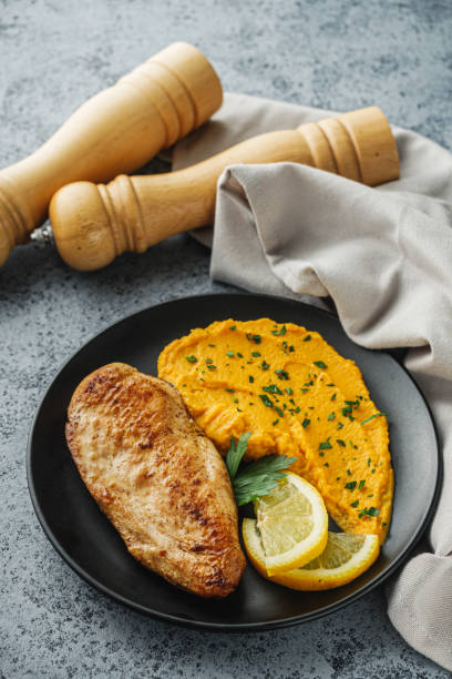istock delicious mashed sweet potatoes and fried chicken breast on a light stone background 2172370858