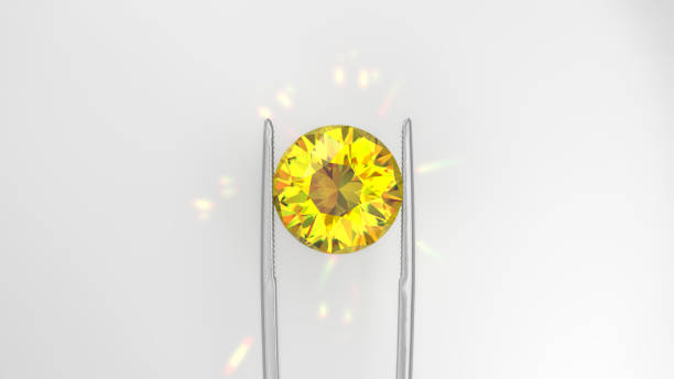 istock Brilliant Yellow Diamond Held by Tweezers 2172371120