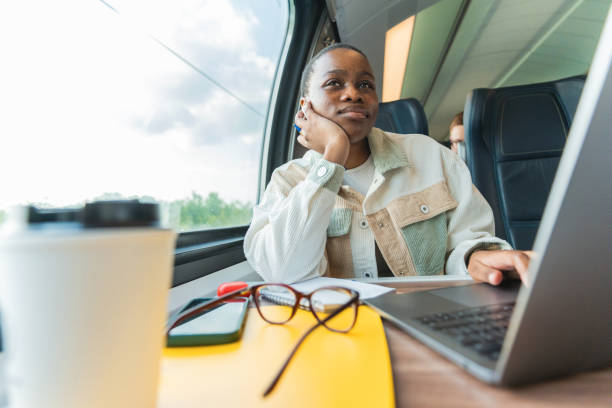 istock A young African-American woman, looking tired while looking out the window during a train ride. 2172372412