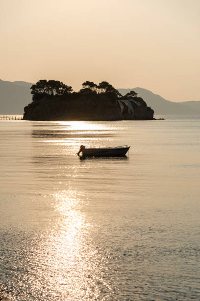 Cameo island, scenic view from the sea. Zakynthos, Greece at dawn. One boat in the foreground.