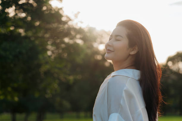 istock Peaceful woman enjoying sunlight outdoors, smiling in a calm natural setting 2172378416