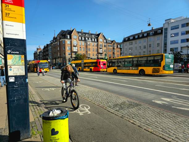 Christanshaven Copenhagen Bus Stop and Subway Station. The image Shows the Citystreet wirh several public busses and pedestrians, captured during summer season.