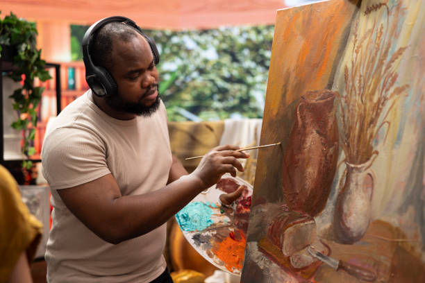 istock Inspired artist working on a canvas with music on headset 2172381677
