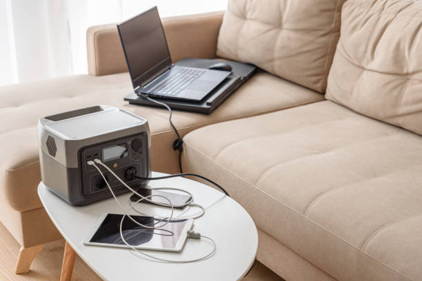 istock Uninterruptible power supply source. Workspace on sofa with laptop, tablet, smartphone and portable power station 2172383689