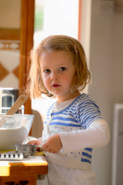 istock Little Girl Baking In Kitchen 2172384523