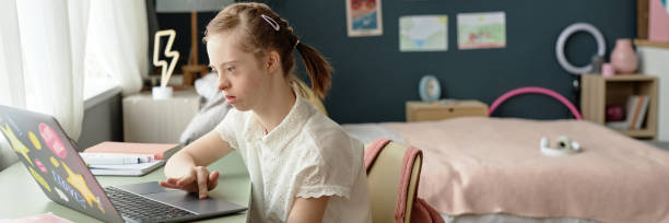 istock Header Image of Girl with Down Syndrome using Laptop 2172384564