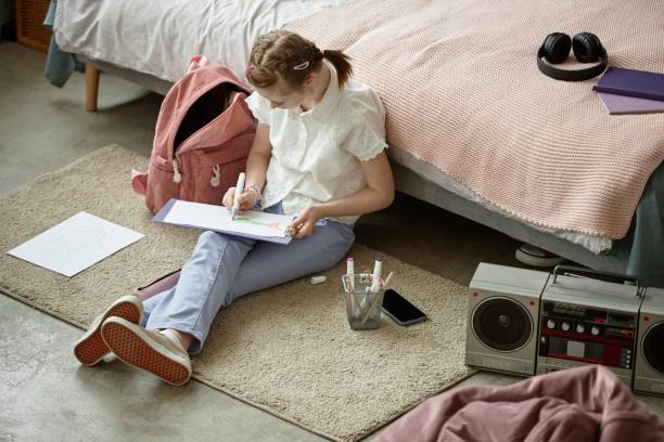istock Young Girl Sitting on Floor Drawing Artwork with Pencil 2172384628