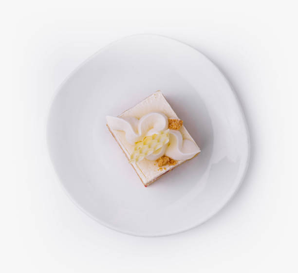 istock Delicious square cake with white icing on white plate 2172384961
