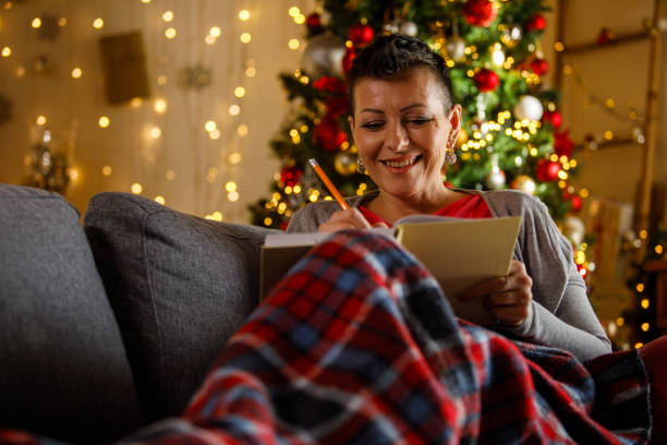 Woman writing journal while enjoying Christmas holidays