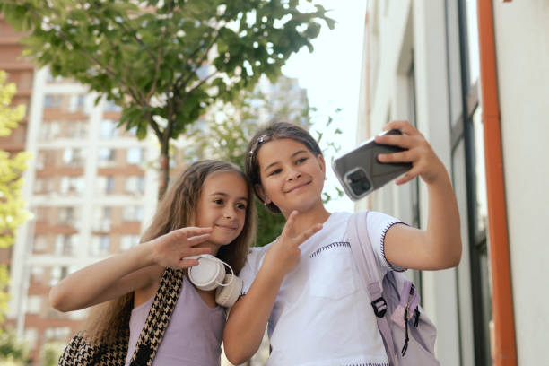 istock Multiethnic elementary middle school. Girls classmates with backpack in casual clothes take a selfie in the school yard. Gen Alpha. Part of a series. 2172393916