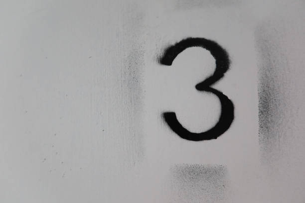 close up of black number three (3) painted on the white floor that is old and torn out with copy space