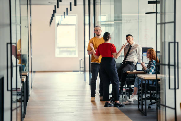 istock A dynamic group of young entrepreneurs engages in vibrant discussion within a modern glass office space, exploring new business projects and fostering innovation 2172398655