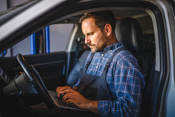 istock Car mechanic use laptop inside car for diagnostics in garage 2172398821