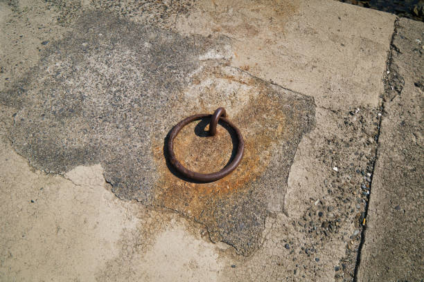 Close-up of an old iron chain securing a stone post in an urban street in the historic center of León, outside Plaza San Isidoro. Urban squares and streets in the center of León in autumn. León, Castile and León, Spain - September 22, 2024.