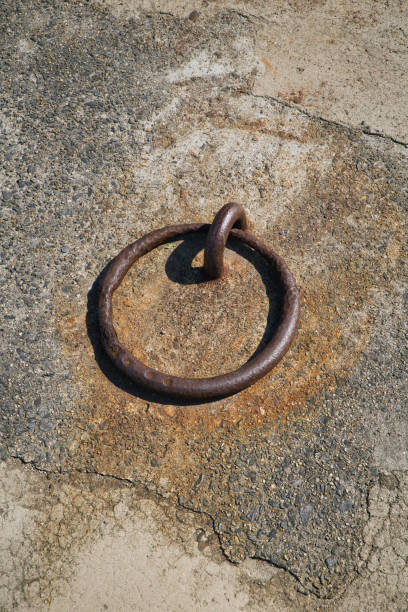 istock Rusty chain attached to an anchor attached to a dike 2172398960