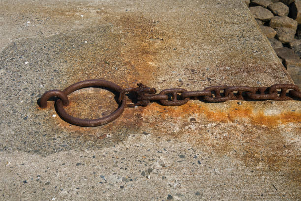 Rusty chain attached to an anchor attached to a dike