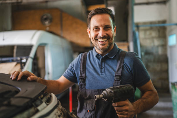 istock Happy car mechanic with power tool in a bright auto workshop 2172400163