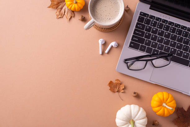 istock A cozy autumn-themed workspace featuring a laptop, glasses, coffee cup, and pumpkins, evoking warm and creative vibes for seasonal office inspiration 2172401447