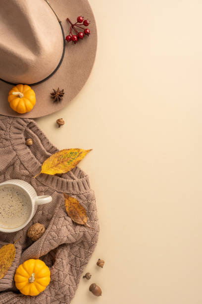 istock Warm vertical autumn scene featuring a sweater, hat, and coffee cup surrounded by leaves, acorns, and pumpkins creating a cozy atmosphere 2172401606