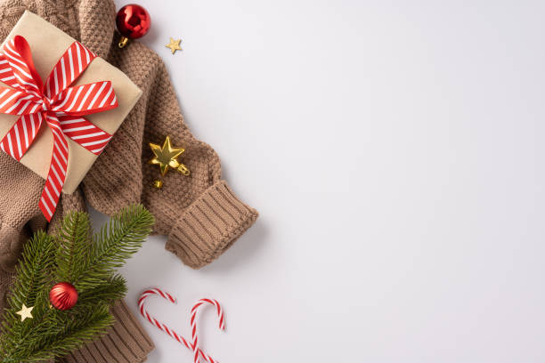 istock Warm Christmas setting featuring a cozy sweater, a wrapped gift, festive ornaments, and candy canes with a holiday spirit 2172401654