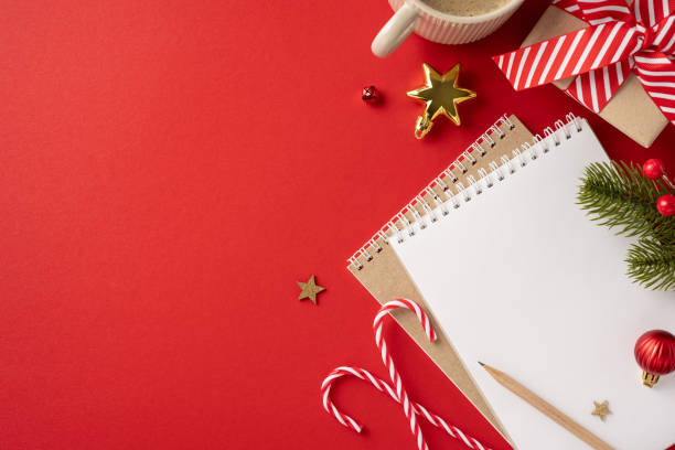 istock Top view of a festive Christmas background featuring a blank notebook surrounded by holiday decorations like candy canes, a gift box, and ornaments 2172401669