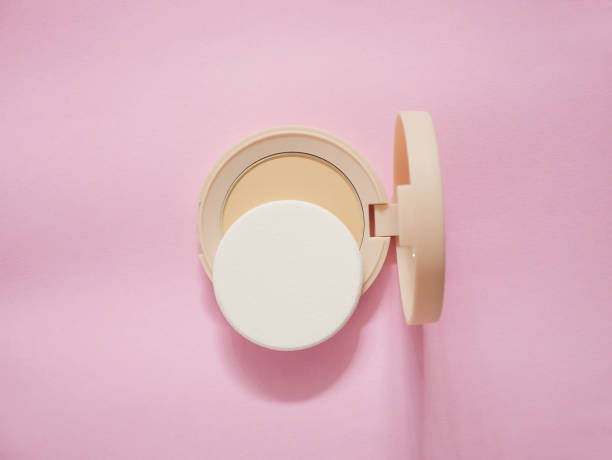 istock Face powder with sponge in beige case on pink background. Top view. 2172403712
