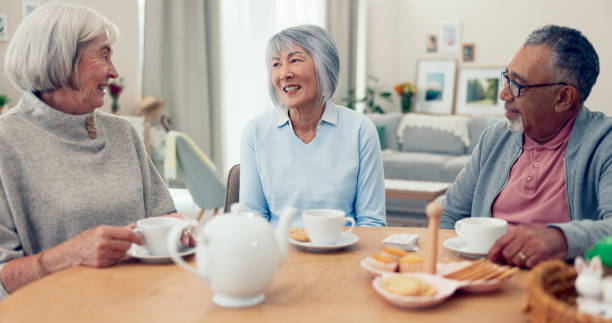 istock Talking, tea and senior group at table for conversation, snacks and retirement together in house. Happy friends, party and man speaking with elderly women for breakfast, communication and bonding 2172403951
