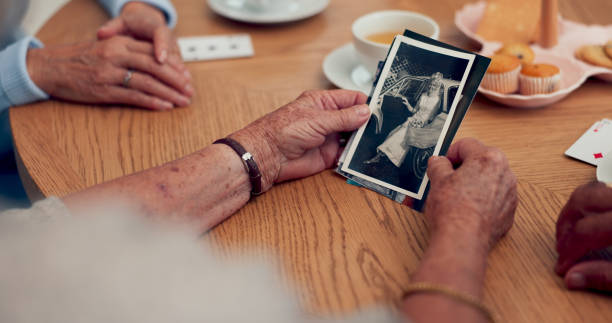 istock Hands, picture and senior people in home with memory, remember or reminiscing in conversation. Talking, photograph and group of elderly friends in discussion for past reflection together in house. 2172404007