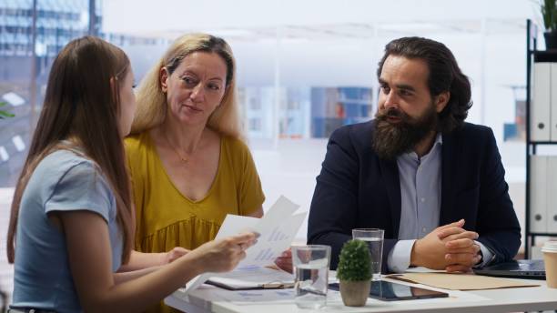 istock Consultant in office assisting people in setting up living expenses plan 2172404505