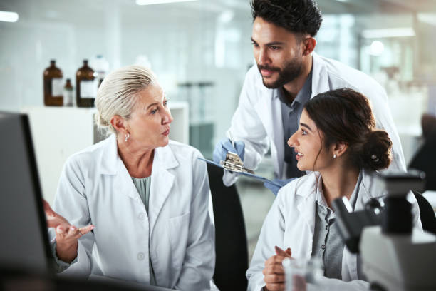 istock Computer, discussion and manager with scientists in lab for pharmaceutical innovation with drug trial. Research, help and mentor with biomedical students with internship for analytical chemistry. 2172404866