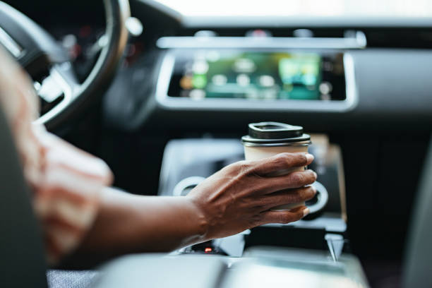 istock Businesswoman Enjoys Coffee While Driving in Modern Car 2172409229