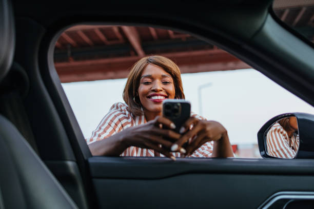 istock Smiling Businesswoman Using Smartphone Near Car Window 2172409301