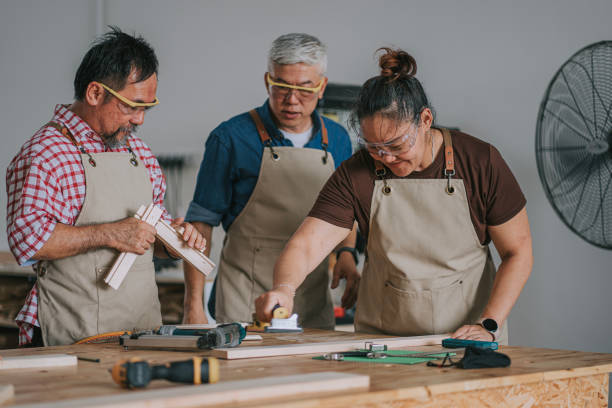 istock Asian chinese carpenter guiding adults students in woodshop workshop class 2172410115