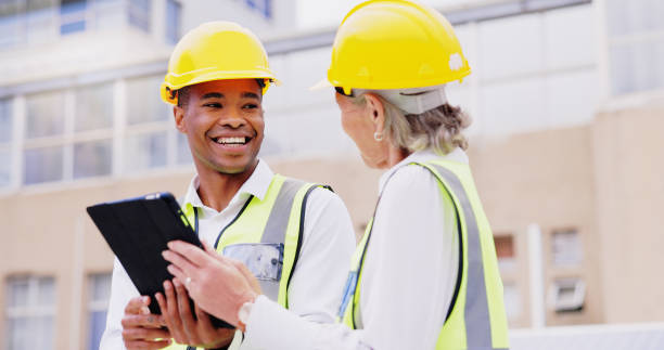 istock Business people, civil engineer and team with tablet for construction, architecture or industrial development in city. Man, woman or builders with smile, safety hard hat or technology for building 2172411466