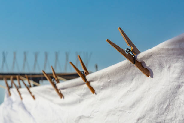 Hanging together - Close-up of a mini wooden clothespin or cloth peg hanging on string to hang art piece Wooden clothespin