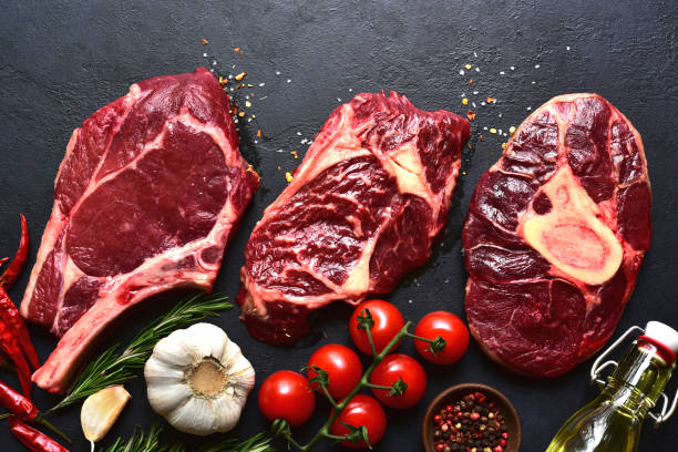 istock Different types of raw marbled beef steaks : T-bone, ossobuco, spider and rib eye with ingredients for cooking . Top view with copy space. 2172415110