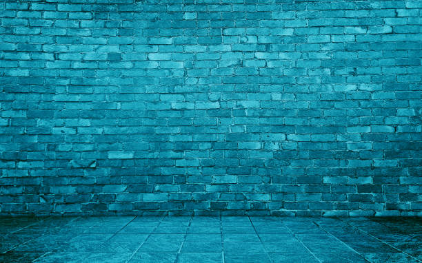 istock blue cyan concrete perspective room for advertising. stamp concrete floor in grid pattern with rustic blue brick wall background. 2172416574