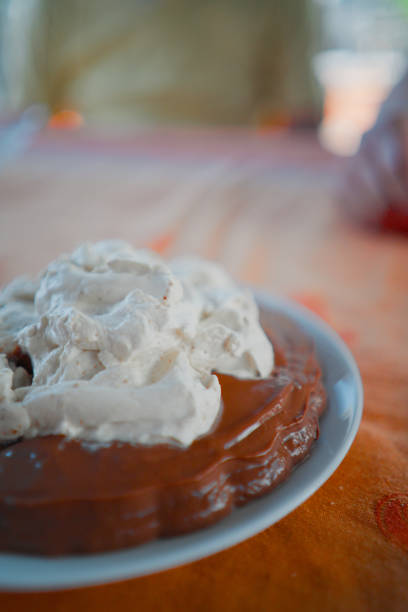 Brown Choclate Pudding with Whipped Cream Topping Standing on a Table