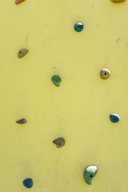 Close up views of rock climbing holds and a rope for belaying in a gym.