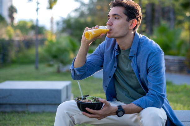 istock Young man in the park eating healthy food during work break 2172435539