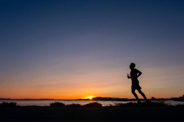 athlete trains at sunset on the seashore.