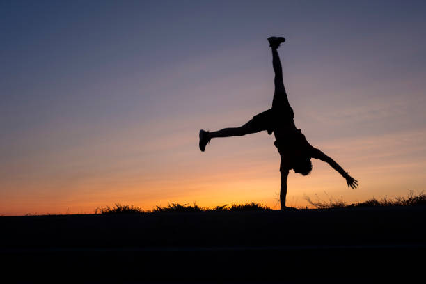 istock athlete doing a cartwheel at sunset. 2172435778