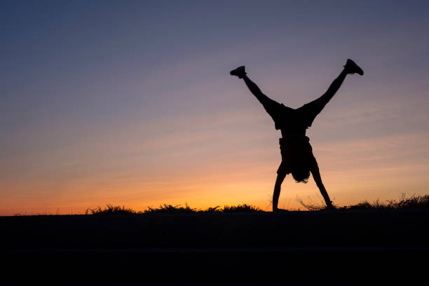 athlete doing a cartwheel at sunset.