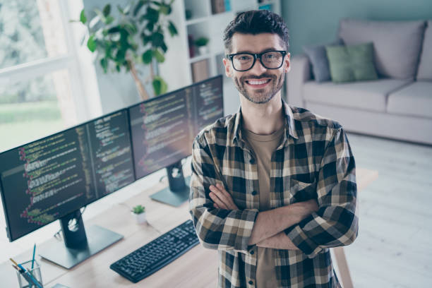istock Photo of confident smiling coder dressed eyewear arms folded indoors workplace workstation loft 2172437165